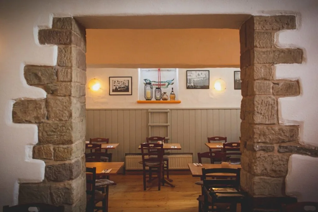 Salle intime de restaurant avec voûte en pierre et petites tables