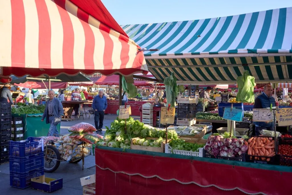 Stands de légumes sous auvents rayés sur le marché de Turin