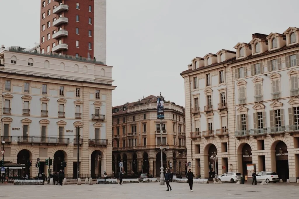 Bâtiments à arcades et passants sur une place animée de Turin